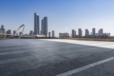 Panoramik siluet ve boş yolu, boş beton zemini olan modern iş binaları.