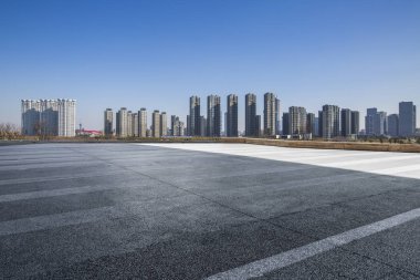 Panoramik siluet ve boş yolu, boş beton zemini olan modern iş binaları.