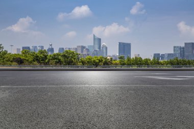 Panoramik siluet ve boş yolu, boş beton zemini olan modern iş binaları.