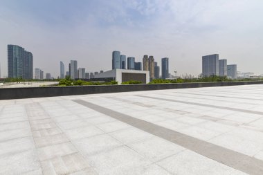 Panoramik siluet ve boş yolu, boş beton zemini olan modern iş binaları.
