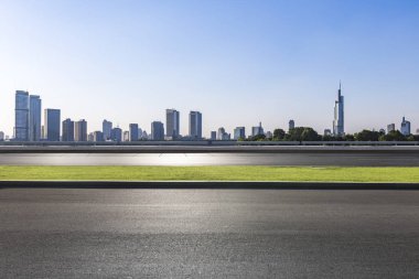 Panoramik siluet ve boş yolu, boş beton zemini olan modern iş binaları.