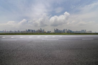 Panoramik siluet ve boş yolu, boş beton zemini olan modern iş binaları.