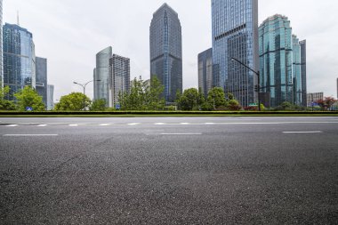 Panoramik siluet ve boş yolu, boş beton zemini olan modern iş binaları.