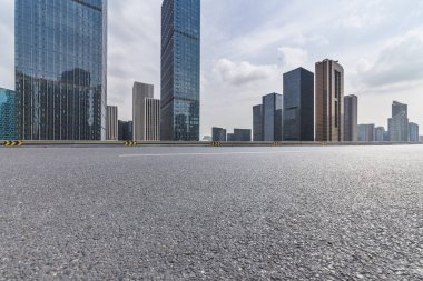 Panoramik siluet ve boş yolu, boş beton zemini olan modern iş binaları.