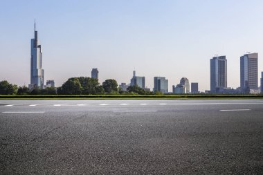 Panoramik siluet ve boş yolu, boş beton zemini olan modern iş binaları.