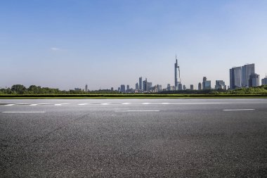 Panoramik siluet ve boş yolu, boş beton zemini olan modern iş binaları.