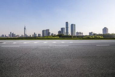 Panoramik siluet ve boş yolu, boş beton zemini olan modern iş binaları.