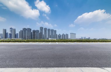 Panoramik siluet ve boş yolu, boş beton zemini olan modern iş binaları.