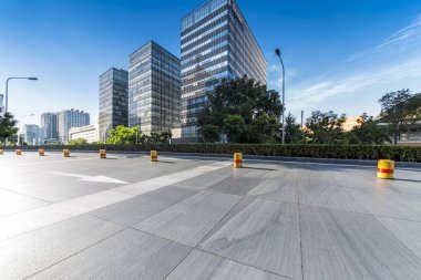 Panoramik siluet ve boş yolu, boş beton zemini olan modern iş binaları.
