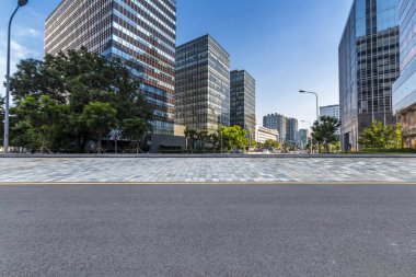 Panoramik siluet ve boş yolu, boş beton zemini olan modern iş binaları.