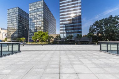 Panoramik siluet ve boş yolu, boş beton zemini olan modern iş binaları.