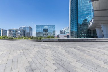 Panoramik siluet ve boş yolu, boş beton zemini olan modern iş binaları.