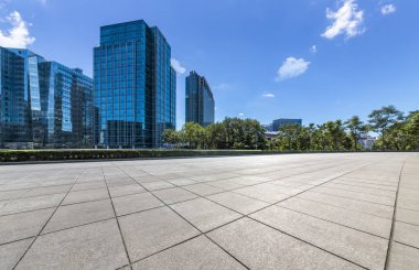 Panoramik siluet ve boş yolu, boş beton zemini olan modern iş binaları.