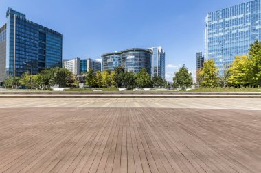 Panoramik siluet ve boş yolu, boş beton zemini olan modern iş binaları.