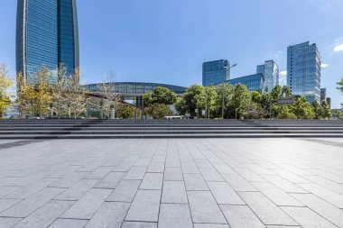 Panoramik siluet ve boş yolu, boş beton zemini olan modern iş binaları.