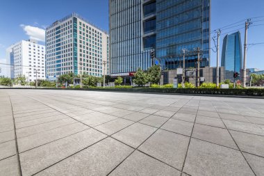 Panoramik siluet ve boş yolu, boş beton zemini olan modern iş binaları.
