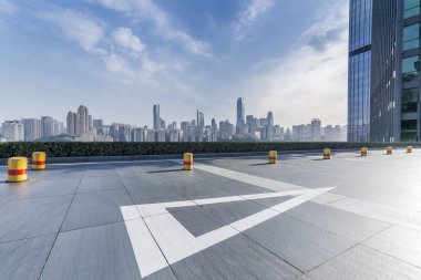 Panoramik siluet ve boş yolu, boş beton zemini olan modern iş binaları.