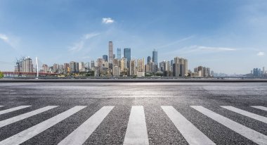 Panoramik siluet ve boş yolu, boş beton zemini olan modern iş binaları.