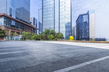 Panoramik siluet ve boş yolu, boş beton zemini olan modern iş binaları.