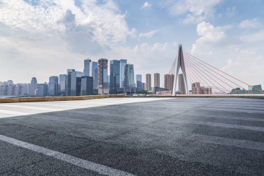 Panoramik siluet ve boş yolu, boş beton zemini olan modern iş binaları.
