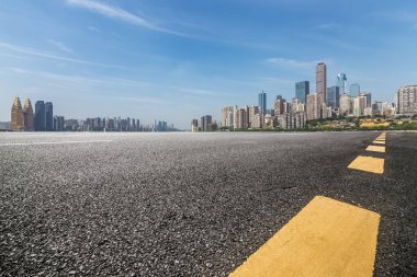 Panoramik siluet ve boş yolu, boş beton zemini olan modern iş binaları.