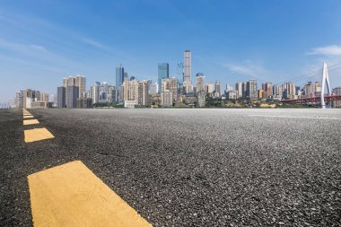 Panoramik siluet ve boş yolu, boş beton zemini olan modern iş binaları.