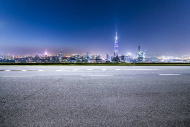 Panoramik siluet ve boş yolu, boş beton zemini olan modern iş binaları.