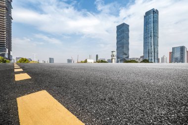 Panoramik siluet ve boş yolu, boş beton zemini olan modern iş binaları.
