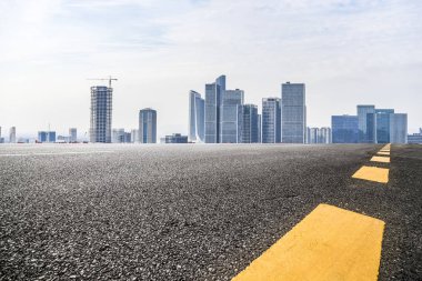 Panoramik siluet ve boş yolu, boş beton zemini olan modern iş binaları.