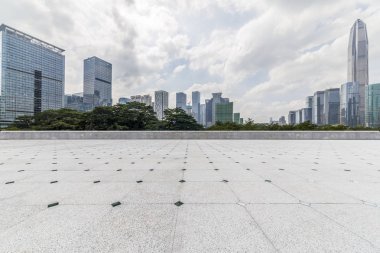 Panoramik siluet ve boş yolu, boş beton zemini olan modern iş binaları.