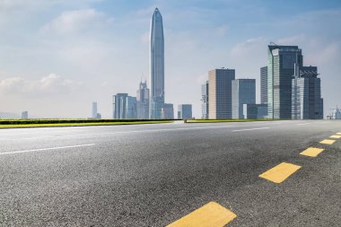 Panoramik siluet ve boş yolu, boş beton zemini olan modern iş binaları.