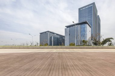 Panoramik siluet ve boş yolu, boş beton zemini olan modern iş binaları.