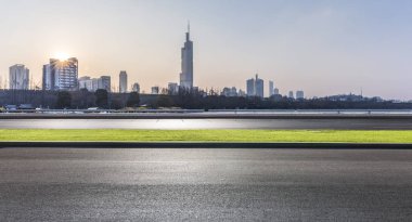 Panoramik siluet ve boş yolu, boş beton zemini olan modern iş binaları.