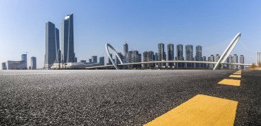 Panoramik siluet ve boş yolu, boş beton zemini olan modern iş binaları.