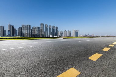 Panoramik siluet ve boş yolu, boş beton zemini olan modern iş binaları.