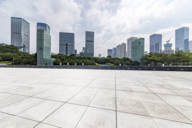 Panoramik siluet ve boş yolu, boş beton zemini olan modern iş binaları.