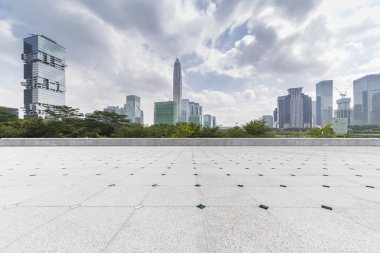 Panoramik siluet ve boş yolu, boş beton zemini olan modern iş binaları.