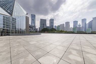 Panoramik siluet ve boş yolu, boş beton zemini olan modern iş binaları.