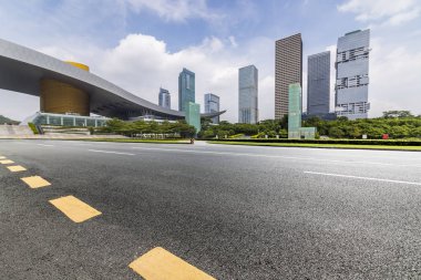 Panoramik siluet ve boş yolu, boş beton zemini olan modern iş binaları.