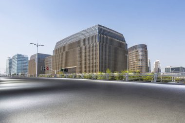 Panoramik siluet ve boş yolu, boş beton zemini olan modern iş binaları.