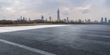 Panoramik siluet ve boş yolu, boş beton zemini olan modern iş binaları.