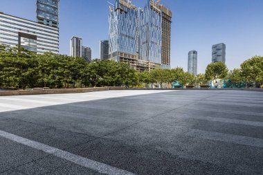 Panoramik siluet ve boş yolu, boş beton zemini olan modern iş binaları.