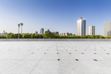 Panoramik siluet ve boş yolu, boş beton zemini olan modern iş binaları.
