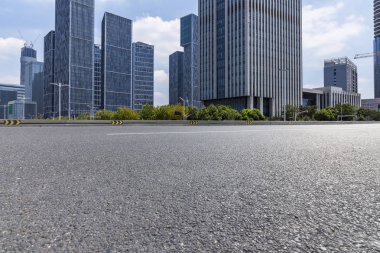 Panoramik siluet ve boş yolu, boş beton zemini olan modern iş binaları.