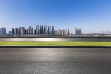 Panoramik siluet ve boş yolu, boş beton zemini olan modern iş binaları.