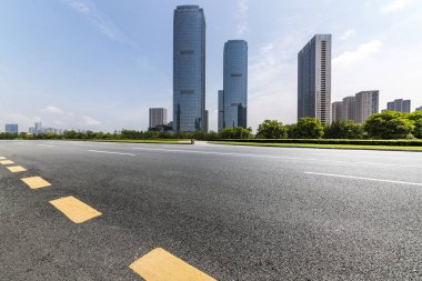 Panoramik siluet ve boş yolu, boş beton zemini olan modern iş binaları.
