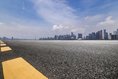 Panoramik siluet ve boş yolu, boş beton zemini olan modern iş binaları.