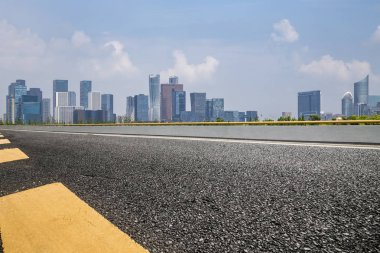 Panoramik siluet ve boş yolu, boş beton zemini olan modern iş binaları.