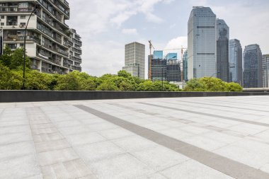 Panoramik siluet ve boş yolu, boş beton zemini olan modern iş binaları.