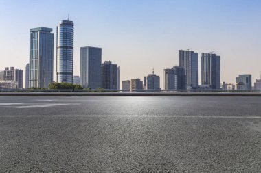 Panoramik siluet ve boş yolu, boş beton zemini olan modern iş binaları.